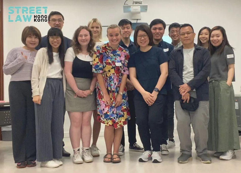 Group of diverse children posing for a photo in a classroom setting, with a "street law hong kong" logo in the top left corner.